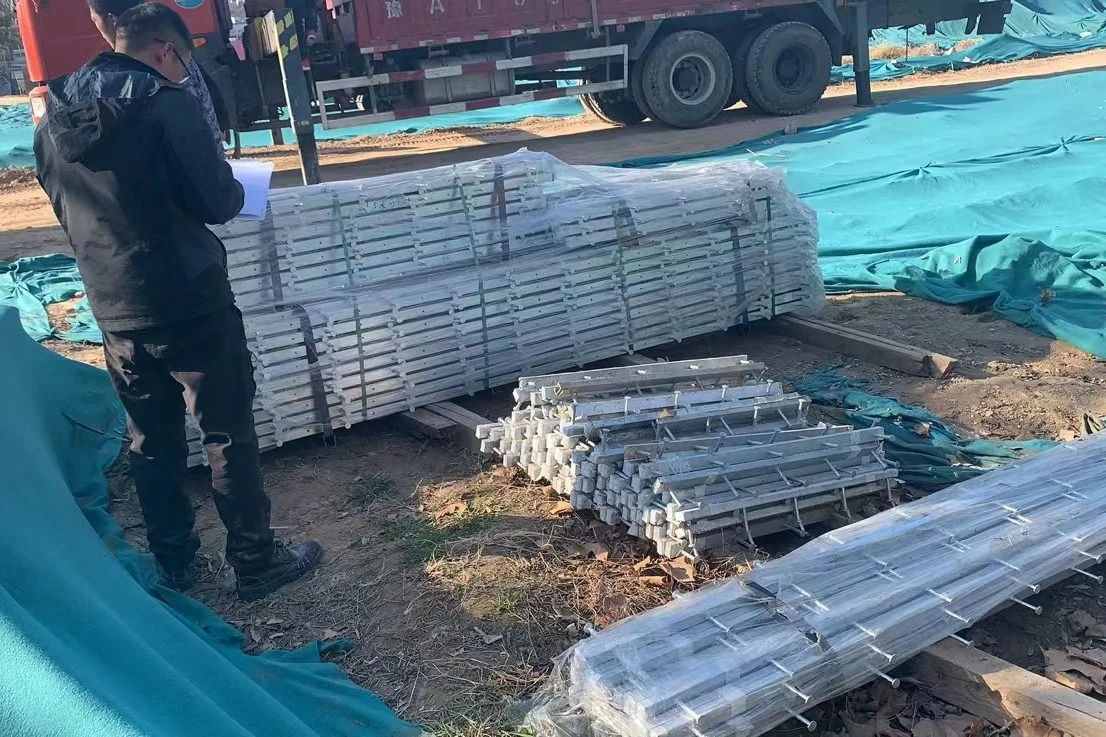 Plastic-wrapped bundles of galvanised profiles being checked at the factory yard