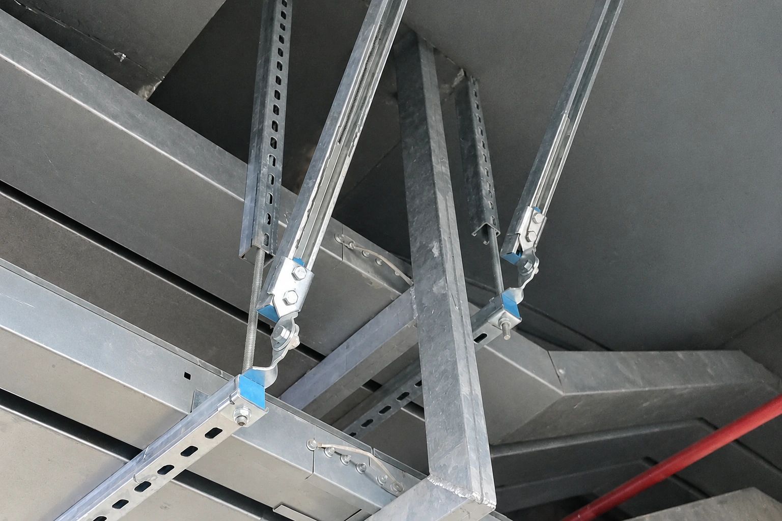 Seismic sway brace of slotted galvanised channel and threaded rod bolted to a ceiling structure