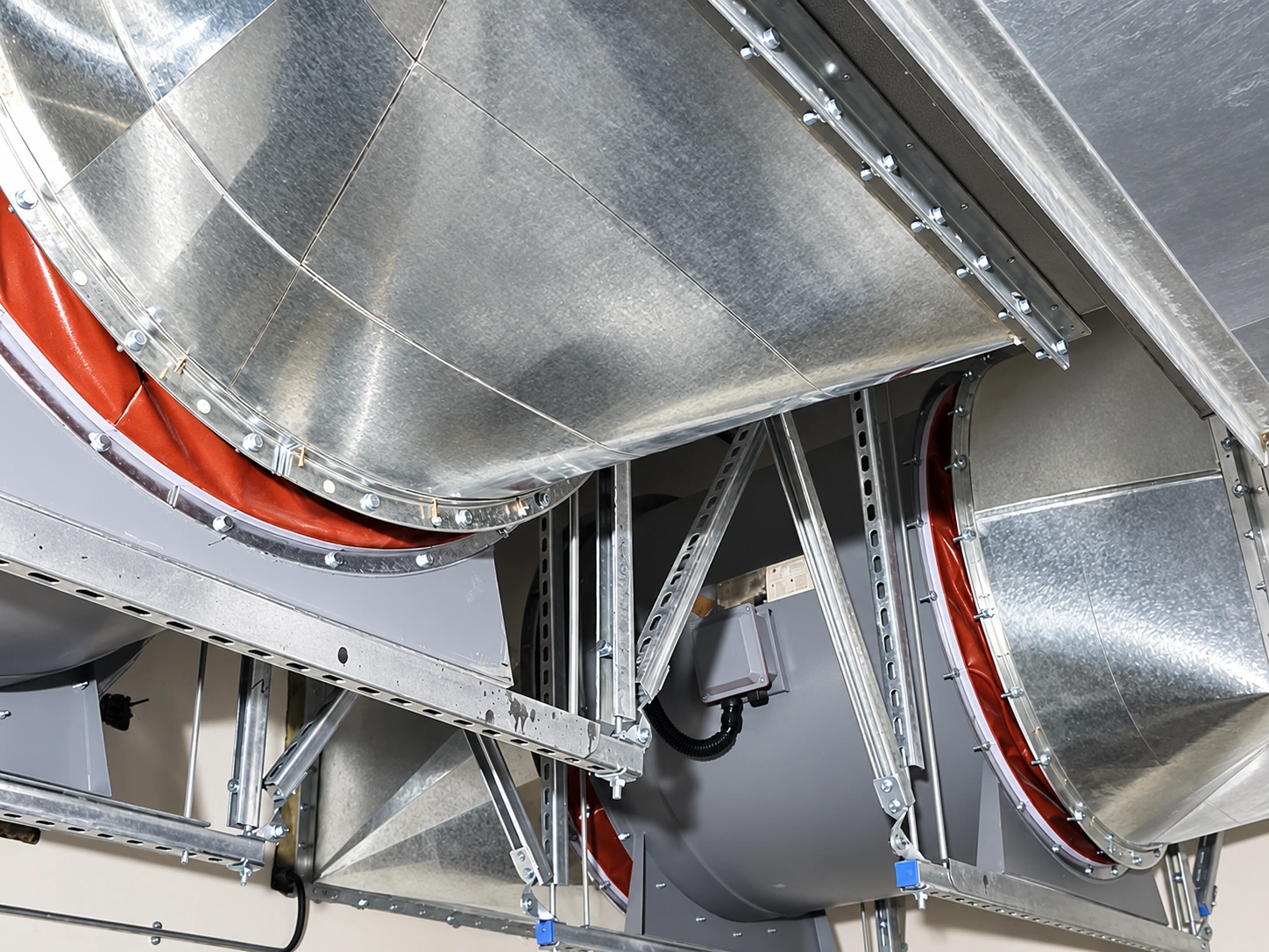 Insulated round and rectangular ducts suspended from galvanised strut channel frames and threaded rods