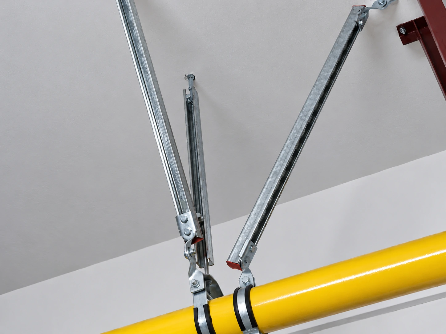 Close-up of an installed seismic sway brace with swivel brackets on a pipe clamp